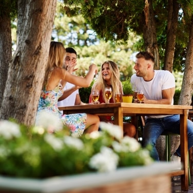 Friends sitting at outdoor table with drinks