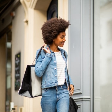 Woman walking with shopping bag and smiling